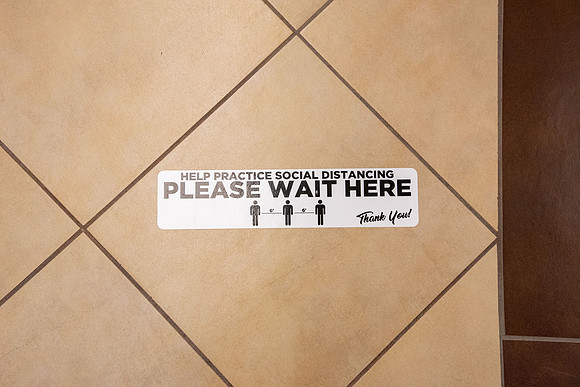 Stickers in the Book Store showing which way to walk down the hallways. The stickers are to direct foot traffic through buildings to try to help fight the virus, COVID-19, on campus.