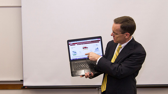 Brother Michael Clark explains to his Productions and Operations Management class how the Root Beer Game works.