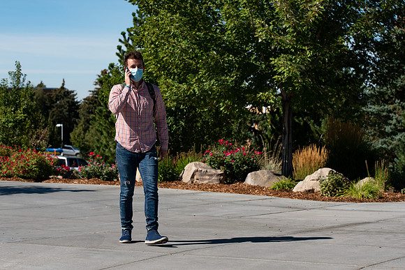 Examples of students staying safe and healthy during the COVID-19 pandemic by social distancing, following pathway arrows, and wearing face masks.