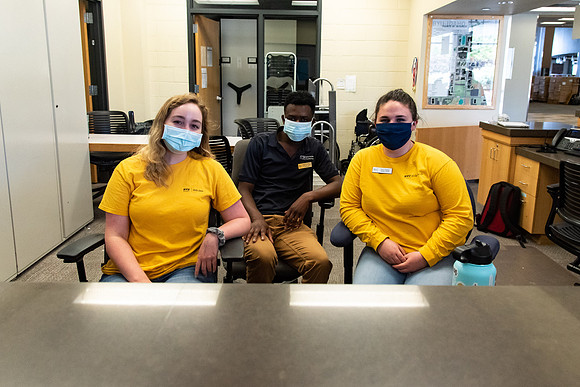 Student employees wearing face masks and working at the Help Desk during the Covid-19 Pandemic.