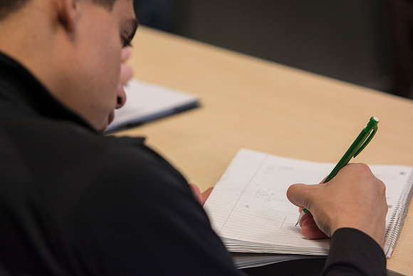 A student in Brother Johanson's Math 109 Precalculus class takes notes.