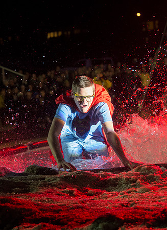 Students make a run down a snowy slope and across a pond of water in the annual event of Pond Skimming.