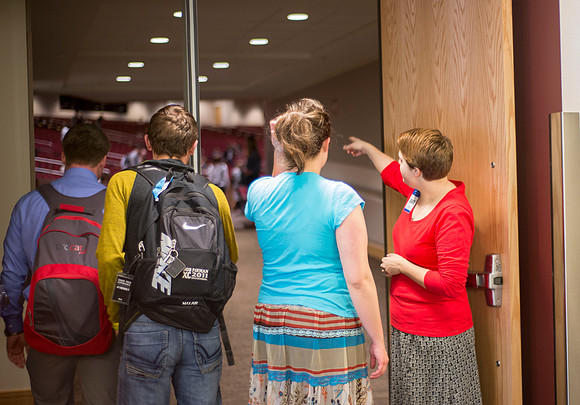 An usher helps devotional attendees find their seating.