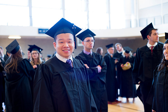 Graduates wait inside the gym area preparing to enter Commencement ceremony.