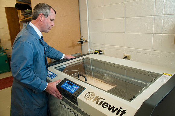 Ron Kinville operates the new Kiewit lazer cutter that was donated to the Architecture and Construction Dept.