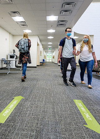 Student volunteers show the way to stay safe during this COVID 19 pandemic by social distancing, following pathway arrows and proper wearing of masks .