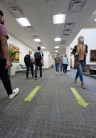 Student volunteers show the way to stay safe during this COVID 19 pandemic by social distancing, following pathway arrows and proper wearing of masks .