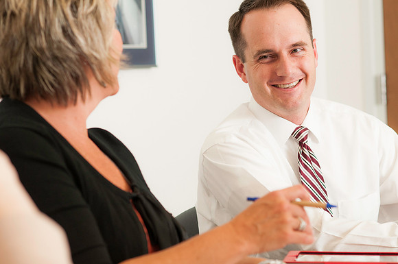 Employees hold a conversation in the Kimball building conference room.