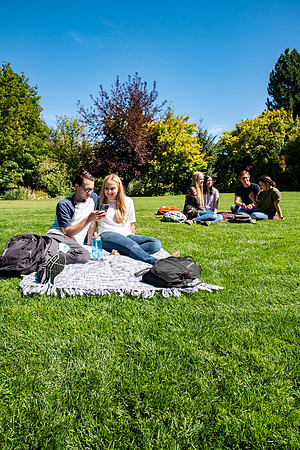 Examples of students staying safe and healthy during the COVID-19 pandemic by social distancing, following pathway arrows, and wearing face masks.