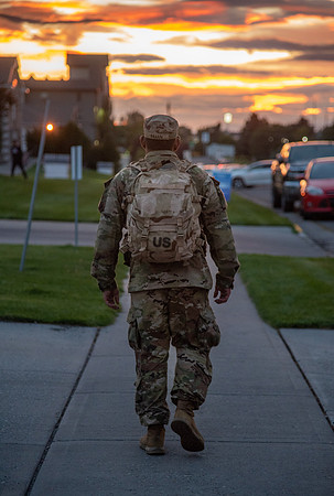 ROTC student walking home in sunset.