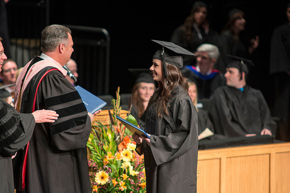 Faculty members hand degrees to and congratualate graduates of the College of Performing and Visual Arts.