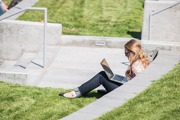 A student passes time between classes outside the MC Building, on the first day of school.