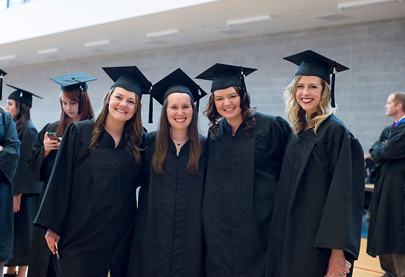 Graduates wait inside the gym area preparing to enter Commencement ceremony.