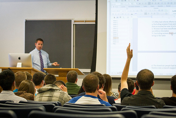 A student raises his hand to ask Brother Hyrum Lewis a question while he teaches American Foundations during the 2014 Spring Semester.
