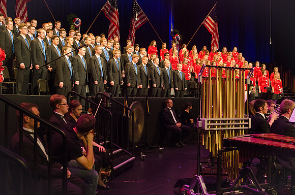 Members of the Collegiate Singers, Men's Choir, Women's Choir, and Symphony Band all perform together at the Patriots and Pioneers Concert.