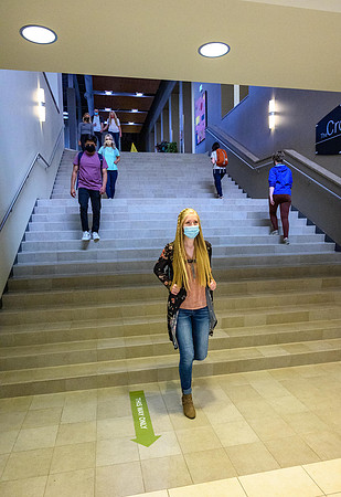 Student volunteers show the way to stay safe during this COVID 19 pandemic by social distancing, following pathway arrows and proper wearing of masks .