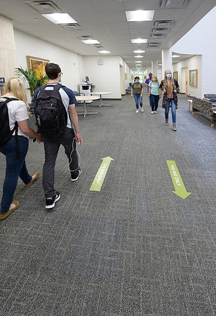 Student volunteers show the way to stay safe during this COVID 19 pandemic by social distancing, following pathway arrows and proper wearing of masks .