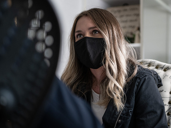 An advisor meets with a student using necessary safety precautions.