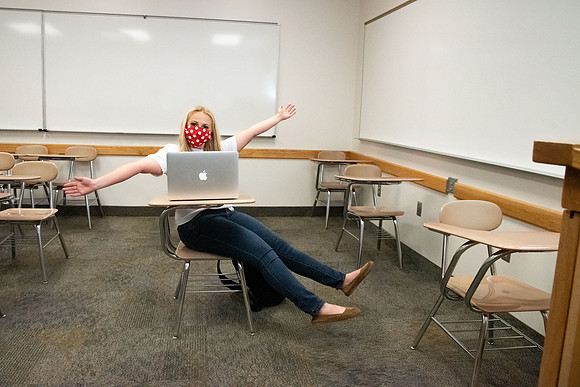 Examples of students staying safe and healthy during the COVID-19 pandemic by social distancing, following pathway arrows, and wearing face masks.