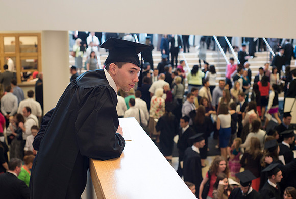 A graduate searches for familar faces in the crowd.
