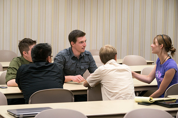 Political Science students in Brother Adamson's class interact with each other as they participate in a hands-on activity during class.