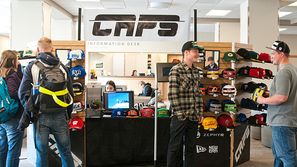 Students from the IBC Business class sell baseball caps in the MC Building.