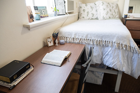 Scriptures on a desk in a clean student bedroom