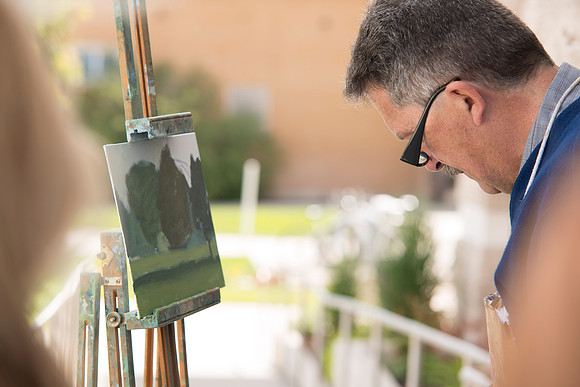 Brother Bodily gives a painting demonstration during his Oil Painting class outside the Spori Building.
