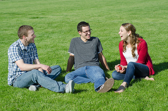 Three friends laugh and enjoy talking on a sunny morning.