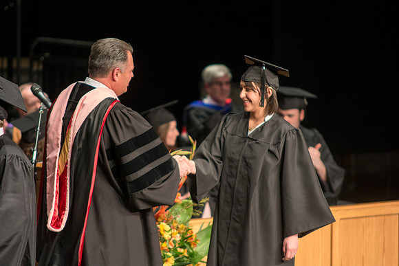 Faculty members hand degrees to and congratualate graduates of the College of Performing and Visual Arts.