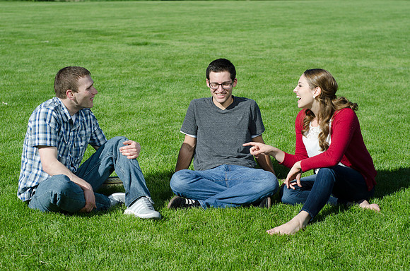 Three friends laugh and enjoy talking on a sunny morning.