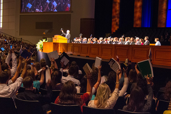 Students raise their notebooks and scriptures, signifying that they are ready to be taught.
