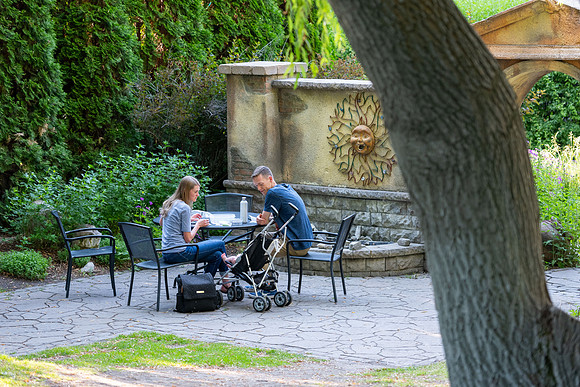 Father, Mother, and child at a table in the Ricks Gardens