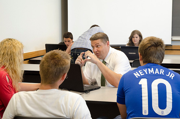 Matt Miles helps students work on group project.