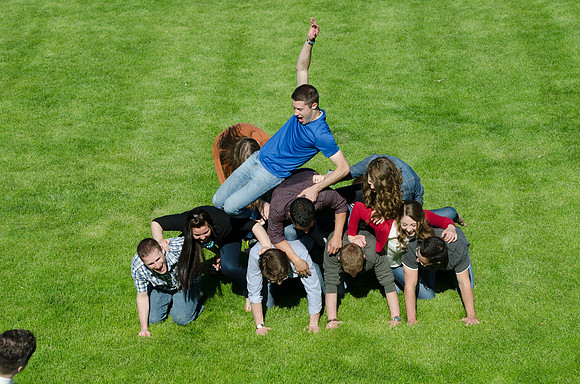Students build and topple in a human pyramid.