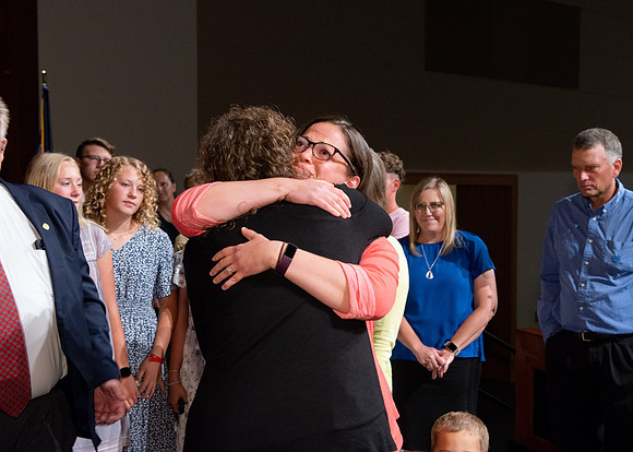 Sister Heather Hall huging her family after devotional.