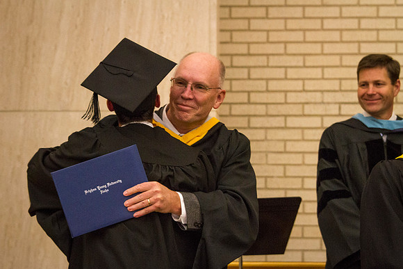 A student gets a hug for receiving his diploma in the Taylor Chapel.