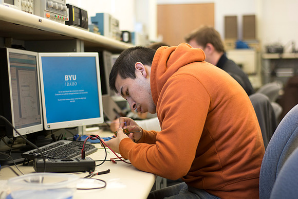 An Electrical Engineer student solders on an electrical component.