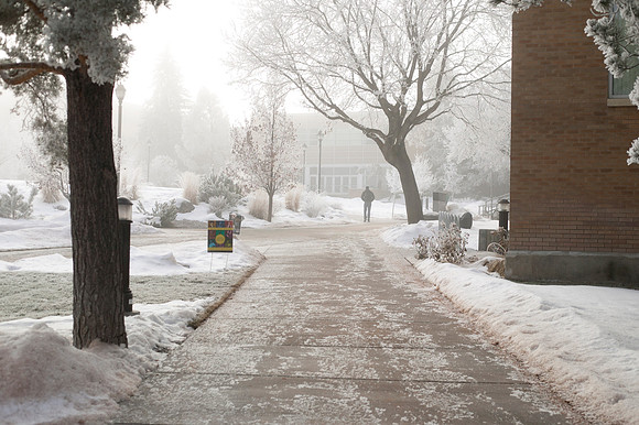 A student walks through a thin wall of fog near the Romney Building.