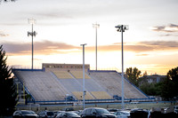 The stadium during sunset with people going up and down the bleacher stairs