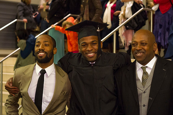 A BYU-I graduate gathers with his family after Commencement in the I-Center.