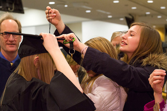 A family helps a graduate fix her cap in the Taylor Chapel after Convocation.