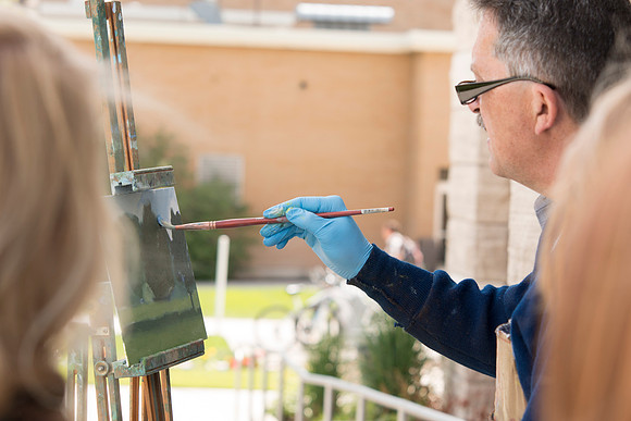 Brother Bodily gives a painting demonstration during his Oil Painting class outside the Spori Building.