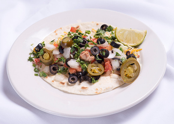 Tomatos, onions olives, jalapeno with lime and cilantro on a tortilla.