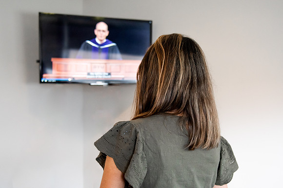 BYUI graduate Renata Flores watches Winter 2021 Commencement in her home with friends.