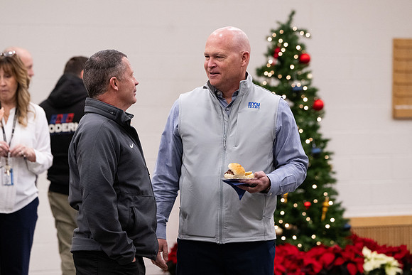 Employees gather for the annual Christmas gathering with President and Sister Meredith.