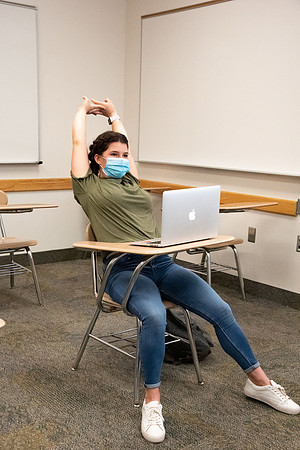 Examples of students staying safe and healthy during the COVID-19 pandemic by social distancing, following pathway arrows, and wearing face masks.