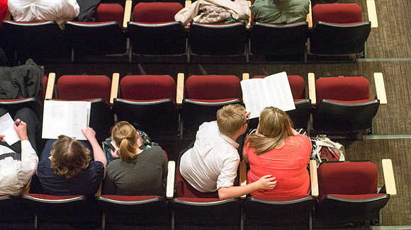Members of the audience look at Commencement program.