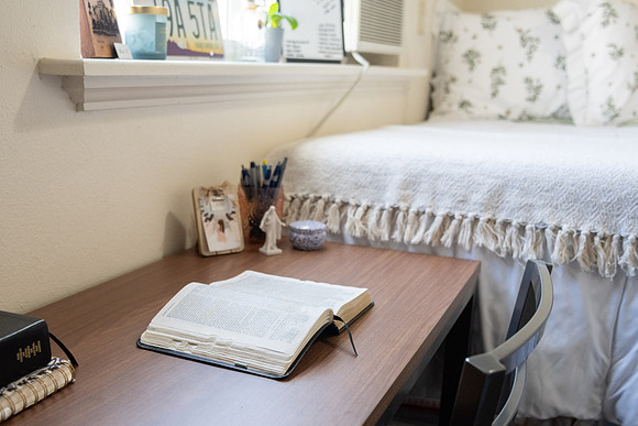 Scriptures on a desk in a clean student bedroom