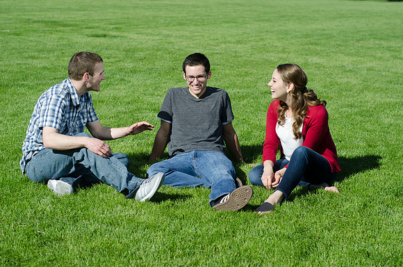 Three friends laugh and enjoy talking on a sunny morning.